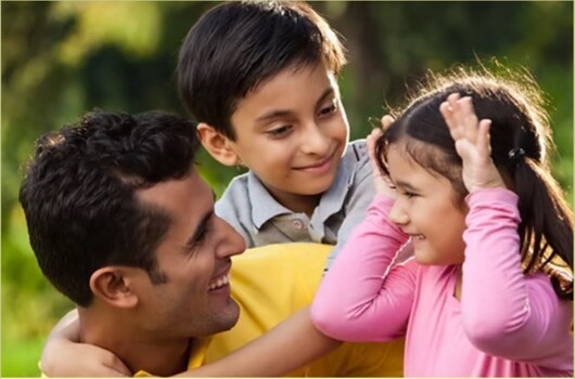 A parent spending time outdoors with two children